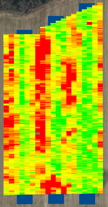 A rectangular soybean strip trial yield map overlaid on an aerial image of a field. The map shows narrow, vertical strips of color-coded yield ranging from red (lowest yield) to dark green (highest yield). Red zones dominate some central and bottom areas, while more green and yellow zones appear across the rest of the field. Blue shaded areas mark headlands or non-harvested areas at the top and bottom of the field.